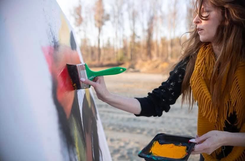 Janet London painting an abstract canvas outdoors